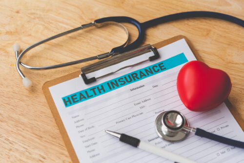 Stethoscope and calculator placed on health insurance documents, Individual medical health insurance. Concept life planning